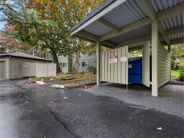 view of vehicle parking featuring mail area and a garage