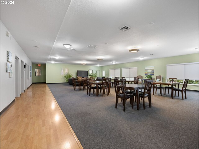 dining space with a textured ceiling and light wood-type flooring