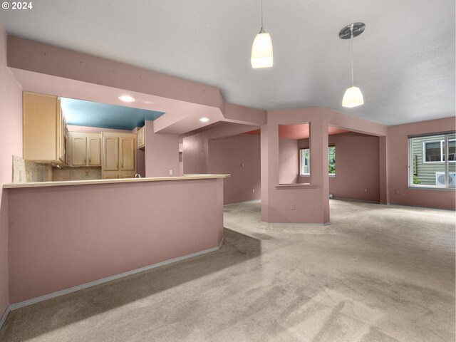 kitchen featuring kitchen peninsula, light carpet, and hanging light fixtures