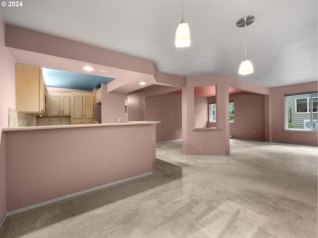 kitchen with open floor plan, pendant lighting, light colored carpet, and baseboards