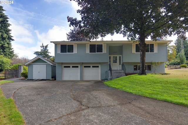 split foyer home featuring a storage shed, a garage, and a front lawn