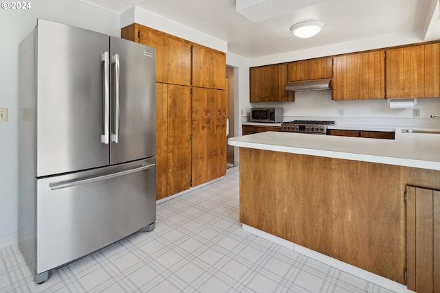 kitchen featuring appliances with stainless steel finishes, kitchen peninsula, sink, and extractor fan