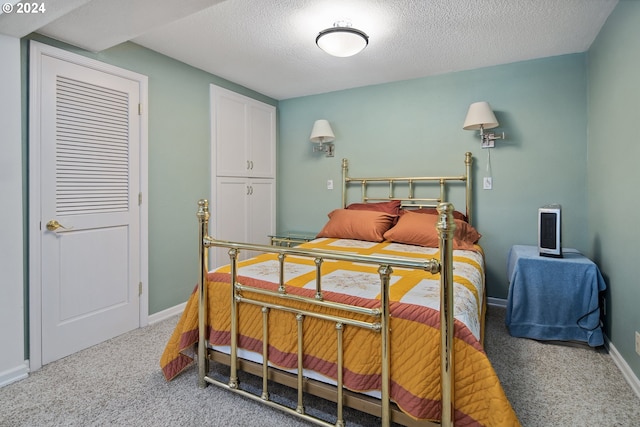 bedroom with a textured ceiling and carpet flooring