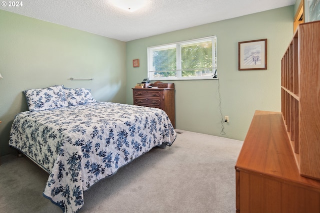 bedroom with a textured ceiling and carpet flooring