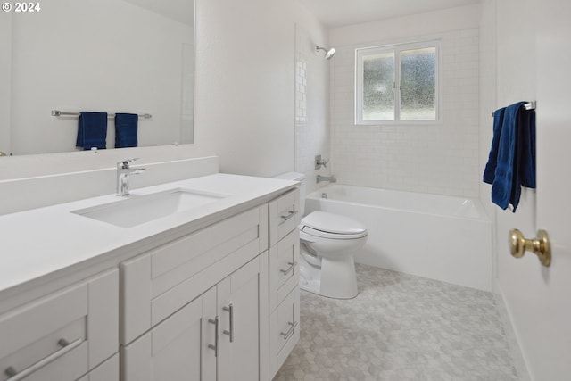 full bathroom featuring vanity, tiled shower / bath combo, and toilet