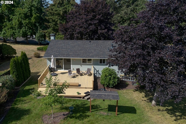 rear view of house featuring a lawn and a deck