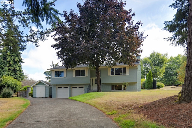 raised ranch with a front lawn and a garage