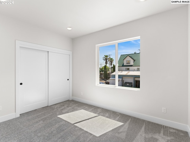 unfurnished bedroom with light carpet and a closet