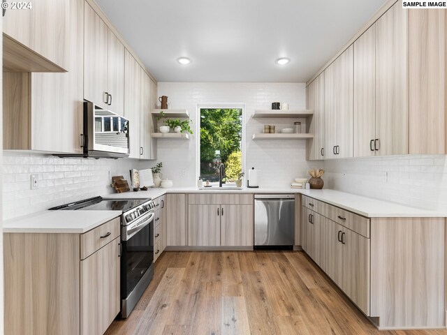 kitchen with stainless steel appliances, light hardwood / wood-style floors, tasteful backsplash, and light brown cabinets