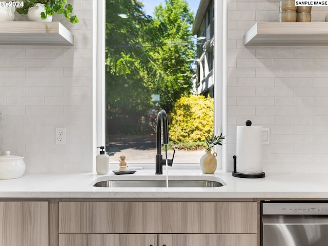 kitchen featuring stainless steel dishwasher, sink, and light brown cabinets