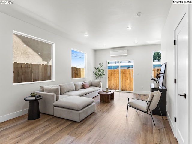 living room with plenty of natural light, a wall mounted air conditioner, and hardwood / wood-style floors