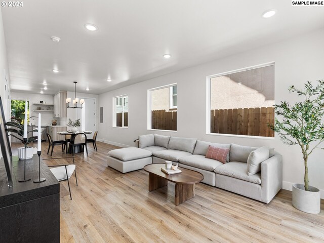 living room with a notable chandelier and light hardwood / wood-style flooring