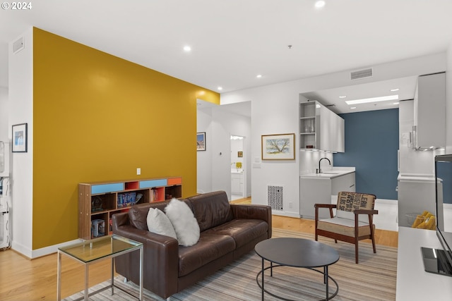 living room featuring sink and light hardwood / wood-style floors