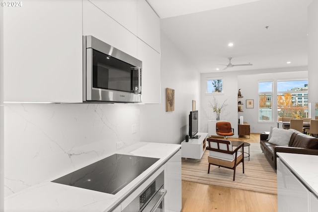 618 NW 12th Ave Unit 409, Portland, OR 97209 - kitchen featuring appliances with stainless steel finishes, light wood-style flooring, white cabinetry, recessed lighting, and a ceiling fan