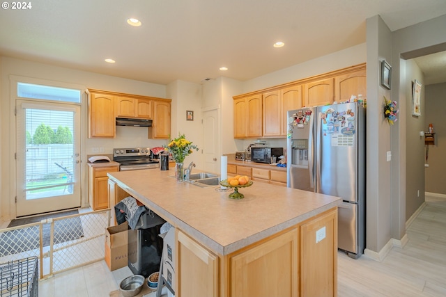 kitchen with a kitchen island with sink, light brown cabinets, stainless steel appliances, sink, and light wood-type flooring