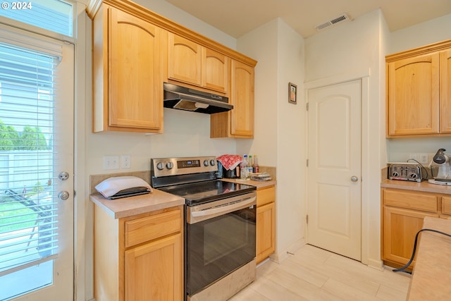 kitchen featuring light brown cabinets, stainless steel electric stove, and light wood-type flooring