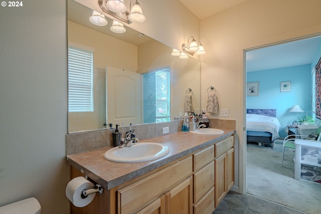 bathroom with vanity, toilet, a notable chandelier, and a wealth of natural light