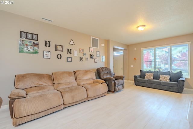 living room featuring light hardwood / wood-style flooring and a textured ceiling