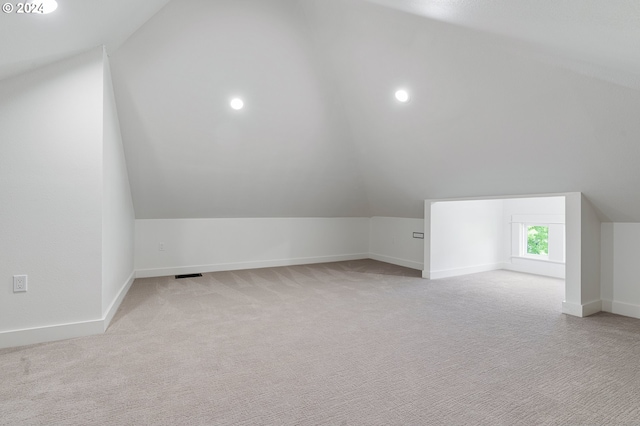 bonus room with light carpet and lofted ceiling