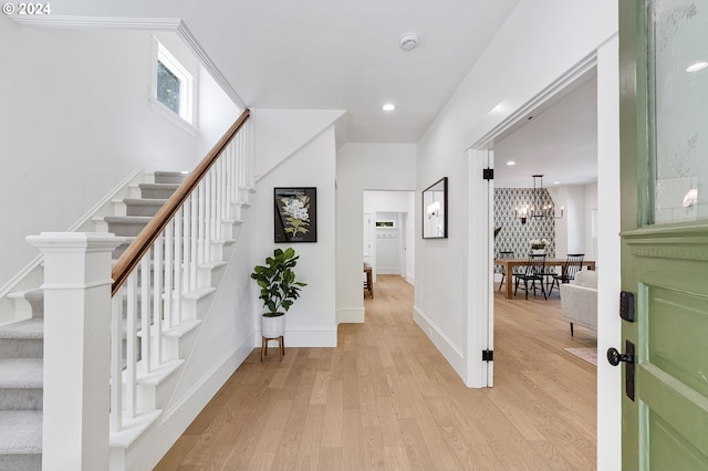 foyer entrance featuring light hardwood / wood-style floors and a notable chandelier