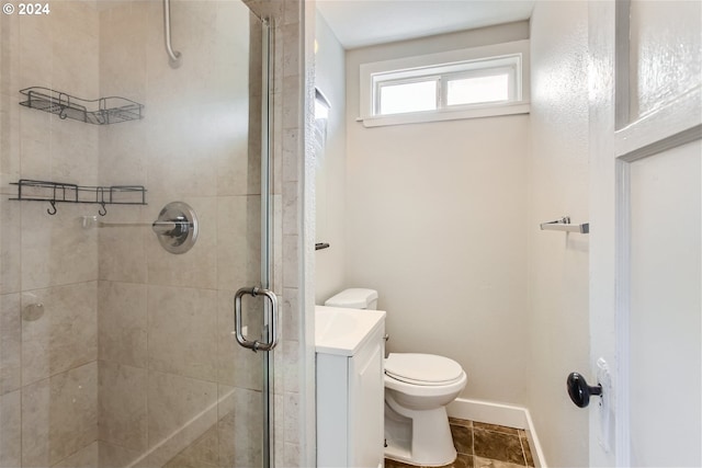 bathroom with a shower with shower door, tile patterned floors, toilet, and vanity