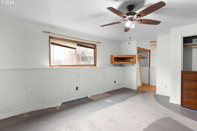 unfurnished bedroom with a closet, a textured ceiling, concrete flooring, and ceiling fan