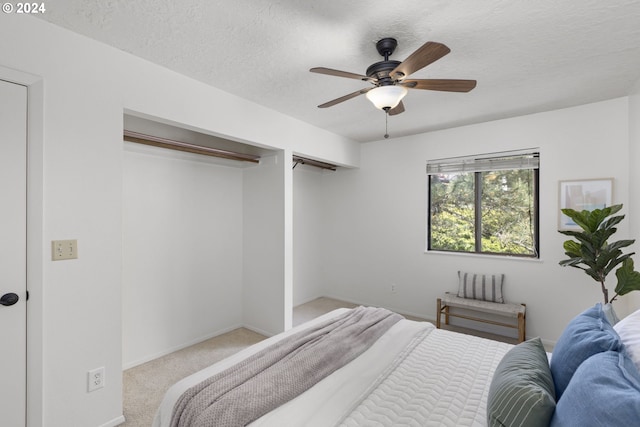 carpeted bedroom featuring a textured ceiling and ceiling fan