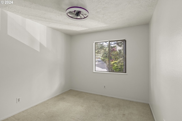 carpeted spare room featuring a textured ceiling