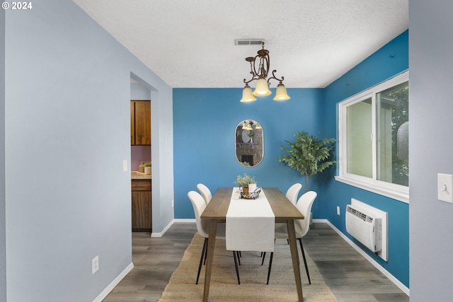 dining space with an inviting chandelier, dark hardwood / wood-style flooring, a textured ceiling, and a wall mounted AC