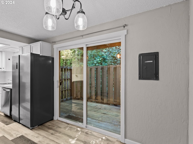 kitchen featuring white cabinetry, electric panel, pendant lighting, appliances with stainless steel finishes, and light wood-type flooring