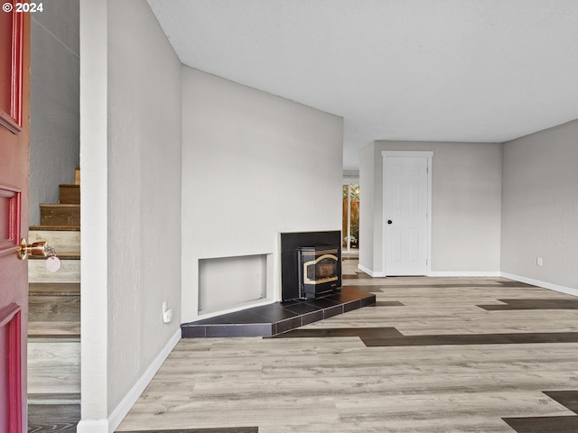 living room with a wood stove and light hardwood / wood-style flooring