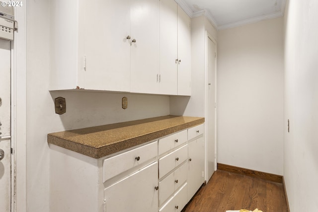 kitchen featuring white cabinets, dark hardwood / wood-style flooring, and crown molding