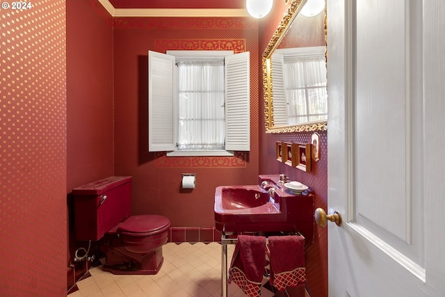 bathroom with tile patterned flooring, toilet, ornamental molding, and sink