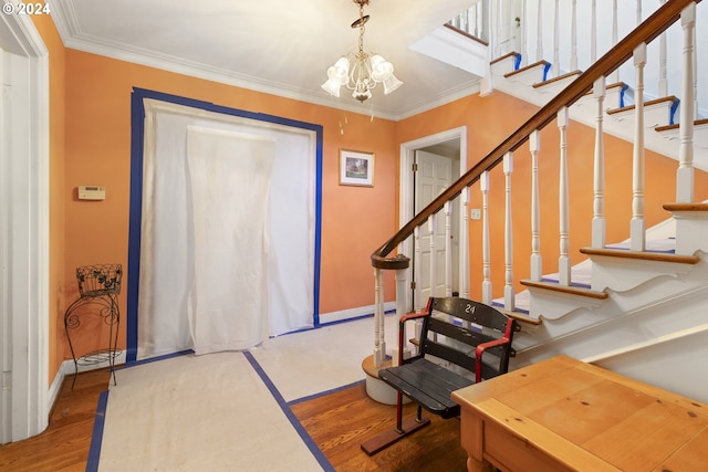 entrance foyer with hardwood / wood-style floors, ornamental molding, and a notable chandelier