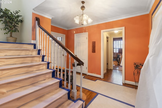 staircase featuring hardwood / wood-style floors, crown molding, and a chandelier