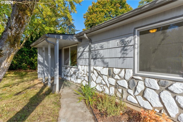 view of exterior entry with a yard