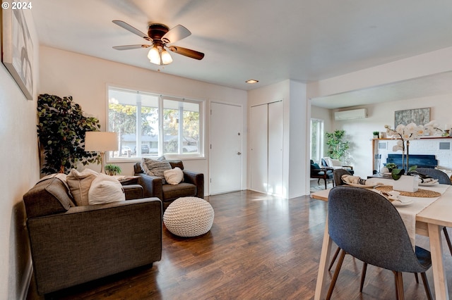 living room featuring a wall mounted air conditioner, ceiling fan, and dark hardwood / wood-style floors