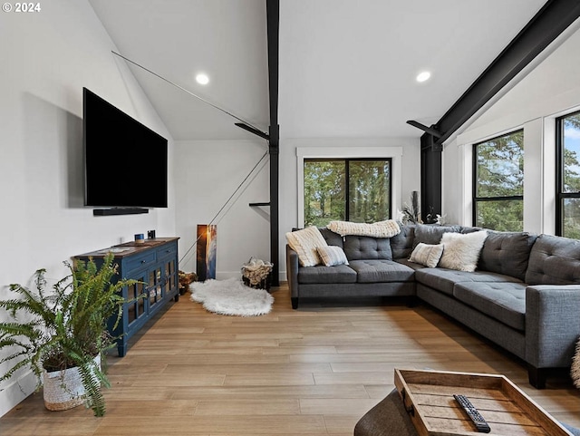 living area with a wealth of natural light, lofted ceiling, light wood-style floors, and recessed lighting