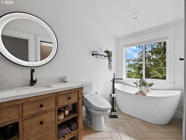 bathroom featuring vaulted ceiling, a tub, toilet, vanity, and parquet floors