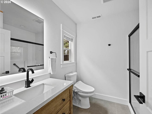 bathroom with vanity, baseboards, visible vents, toilet, and a shower with door