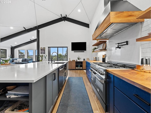 kitchen featuring light hardwood / wood-style flooring, appliances with stainless steel finishes, blue cabinets, a center island with sink, and island range hood