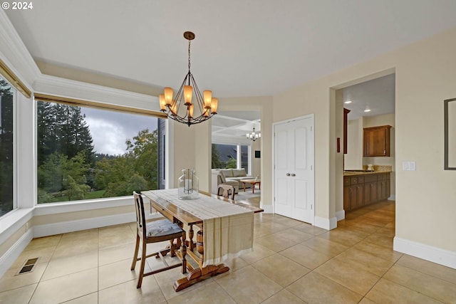 tiled dining space featuring a notable chandelier and a healthy amount of sunlight