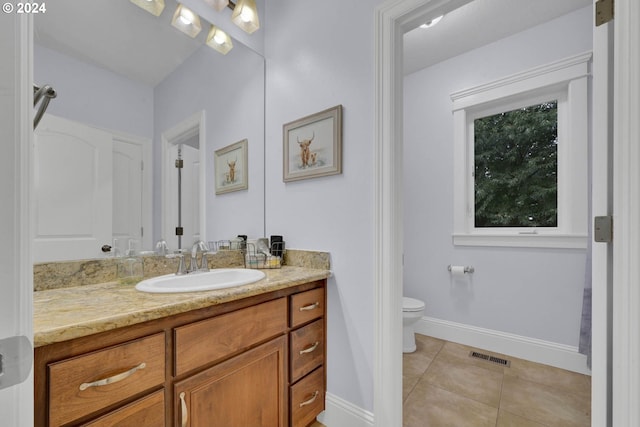 bathroom featuring vanity, tile patterned flooring, and toilet