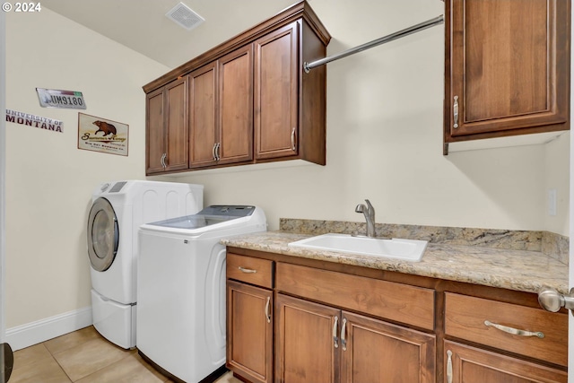 laundry area featuring light tile patterned floors, separate washer and dryer, cabinets, and sink