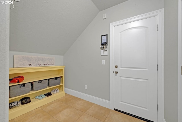 entrance foyer featuring tile patterned flooring and vaulted ceiling