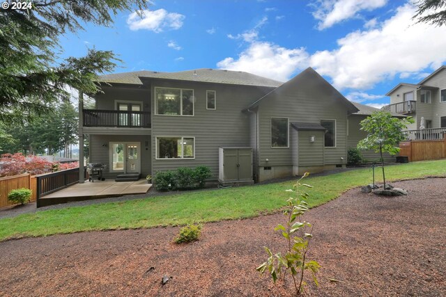 back of house with a balcony, a patio area, and a yard