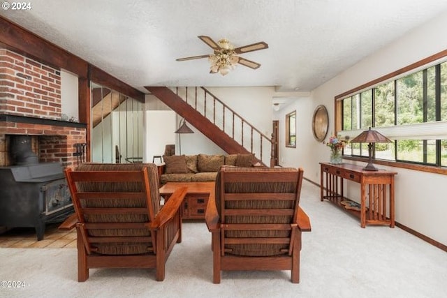 carpeted living room with a wood stove, a textured ceiling, and ceiling fan