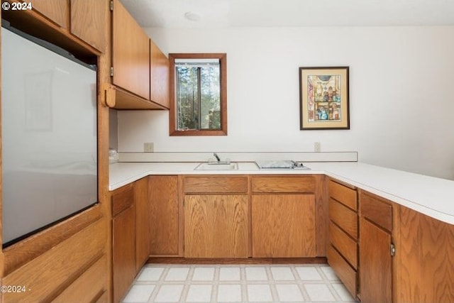 kitchen with light floors, light countertops, and brown cabinets