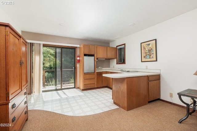 kitchen with kitchen peninsula, light colored carpet, and stainless steel fridge