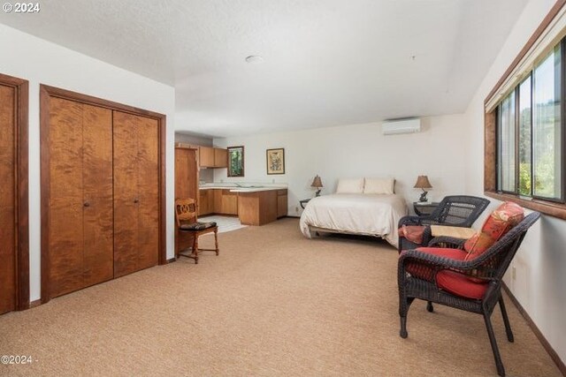 bedroom with a wall unit AC and light colored carpet